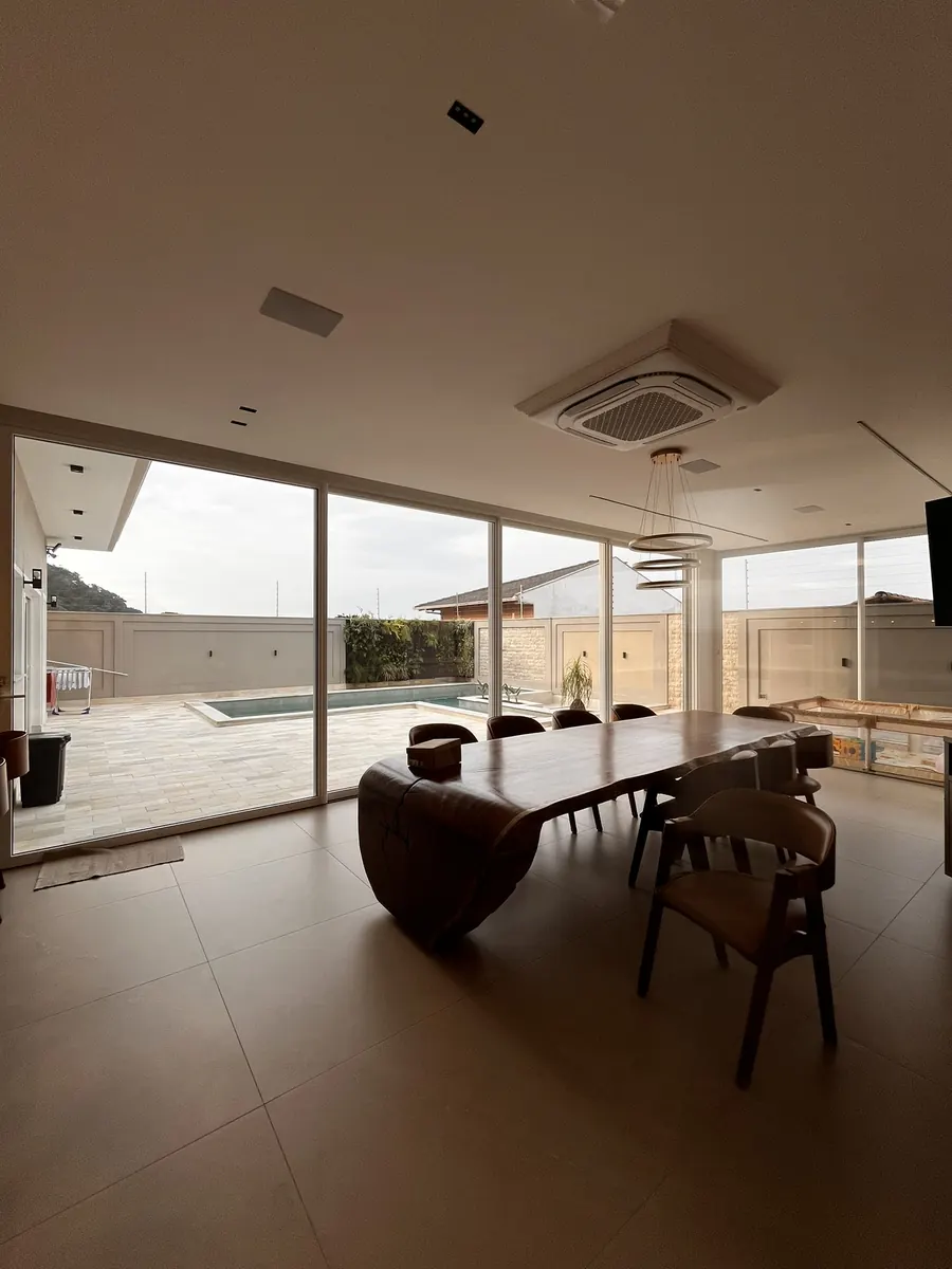 Sala de jantar com vista preservada para a piscina através dos vidros com película