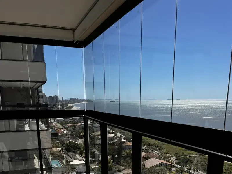 Varanda envidraçada de apartamento frente mar com vista para o oceano